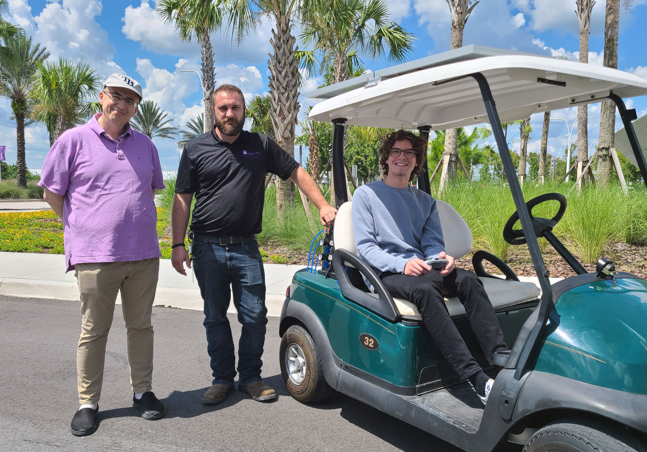 Dr. Onur Toker, Mike Kalman, and Matthew DeCicco demonstrate a drive-by-wire golf cart.
